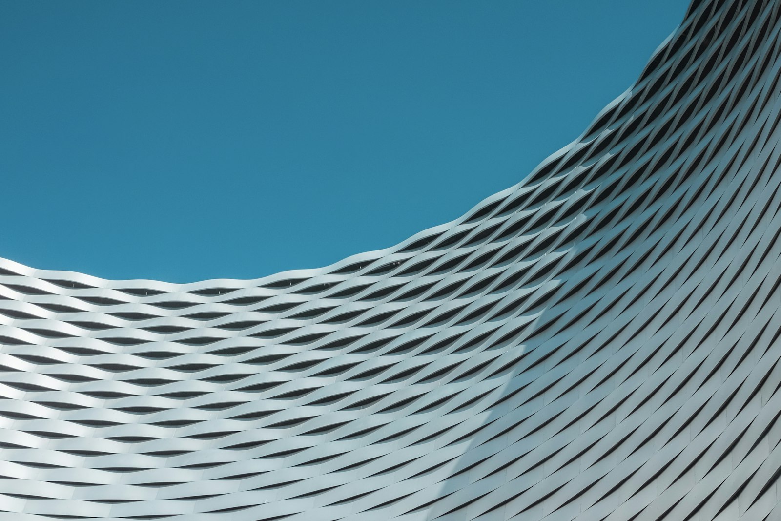 A bright rippled facade against a blue sky
